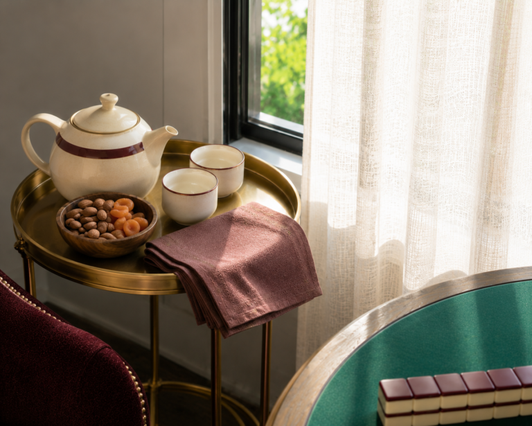 A styled tea and snack station with ceramic teaware beside a game table